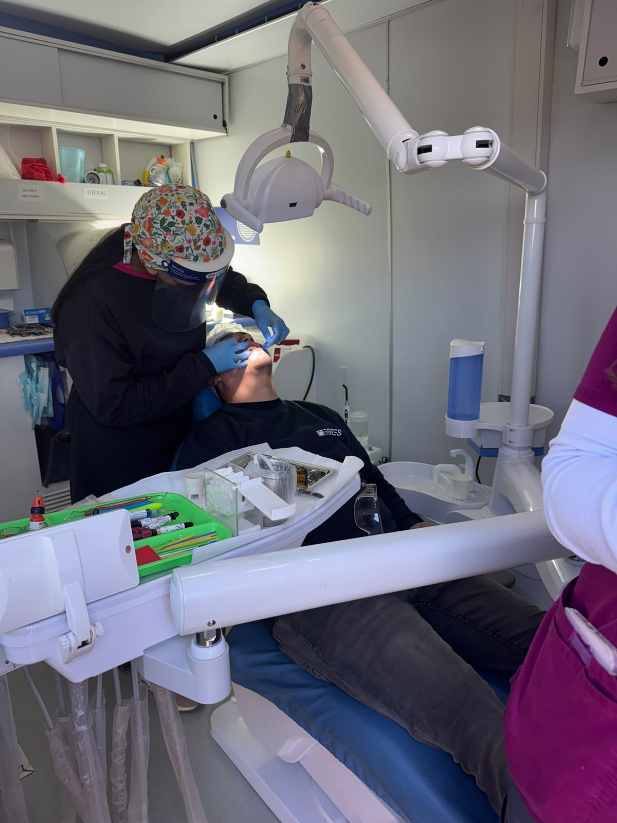Odontóloga realizando una atención dental a un colaborador dentro de la clínica móvil.